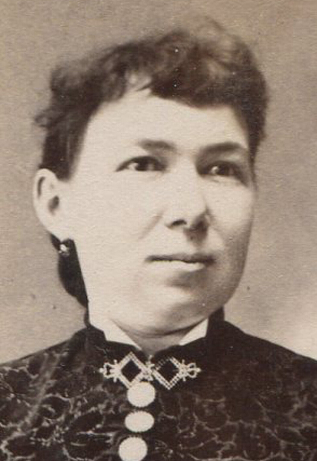 WOMAN, STIFFLY POSED IN COMPLICATED DRESS. CABINET CARD.