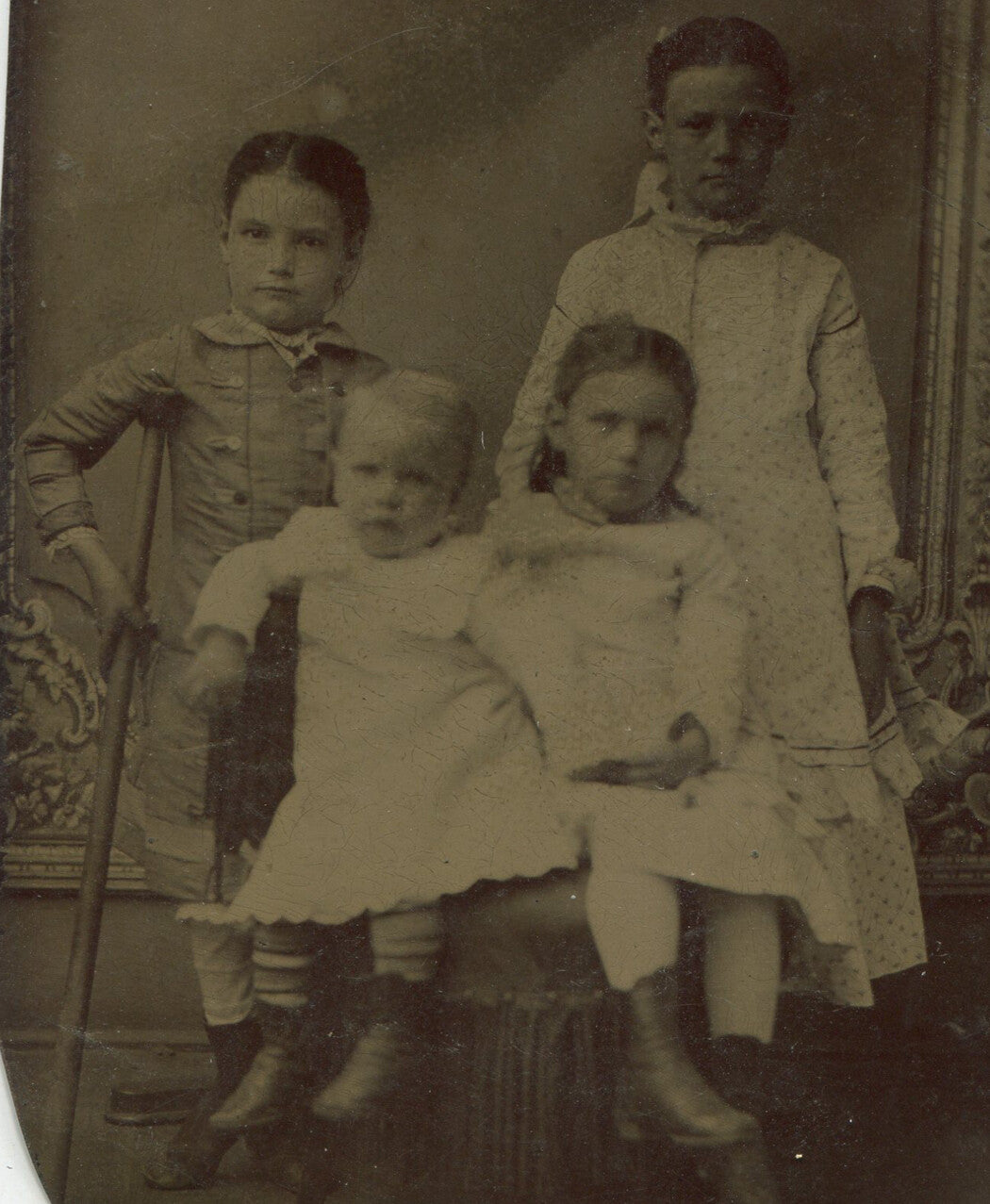 FOUR YOUNG UNHAPPY SIBLINGS, ONE WITH A CRUTCH. TINTYPE.