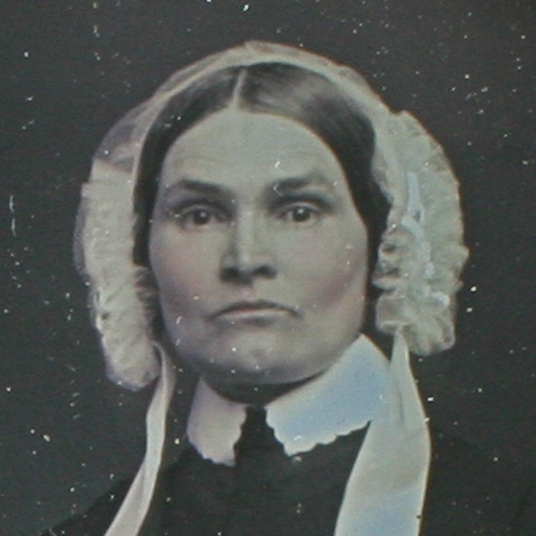 WOMAN, STRONG CHEEK BONES, BONNET. TINTED 6TH PLATE DAGUERREOTYPE, FULL CASE.