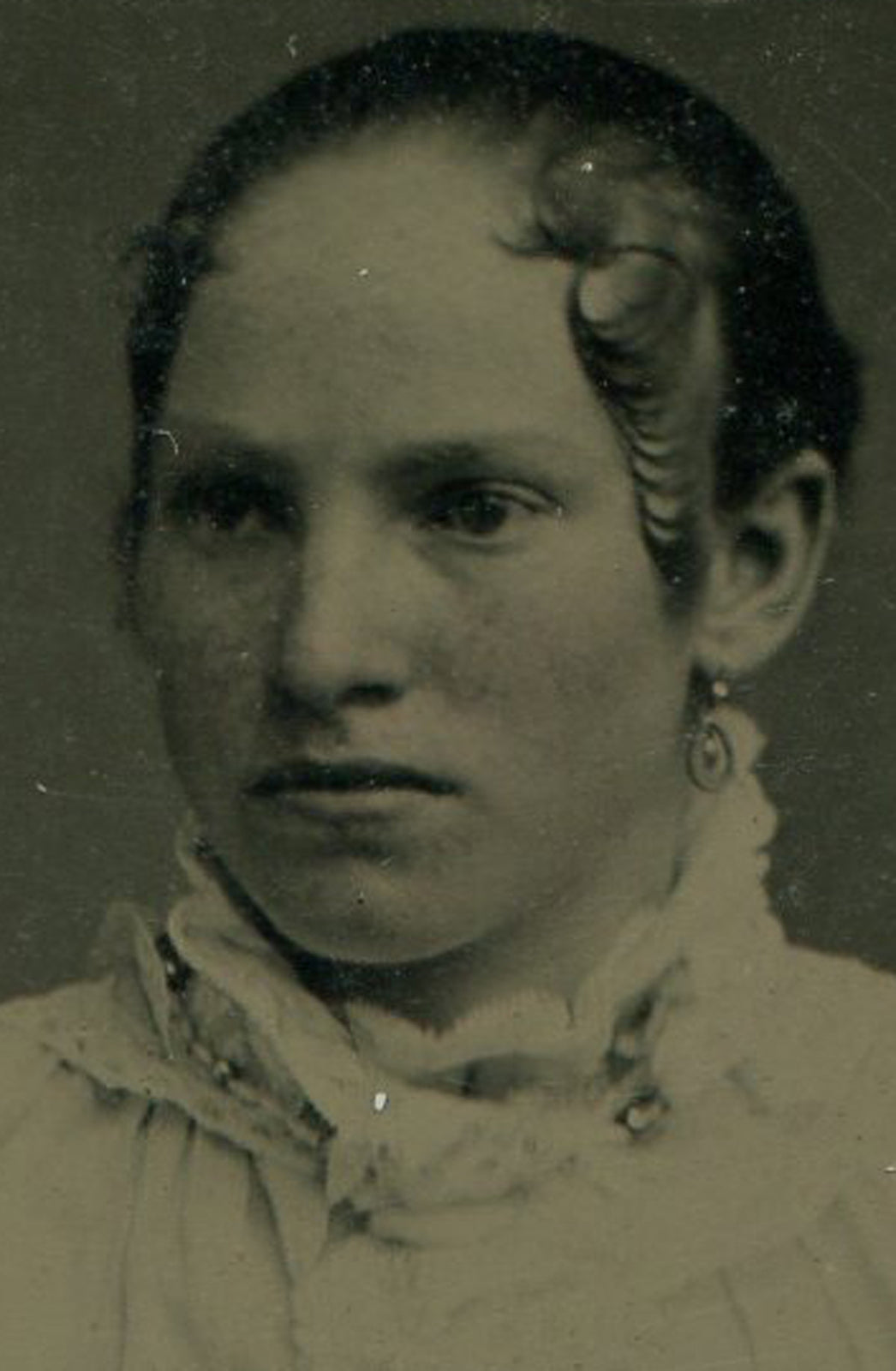 YOUNG WOMAN W/ SERIOUS PIN CURLS. TINTYPE IN PERIOD PAPER MAT.