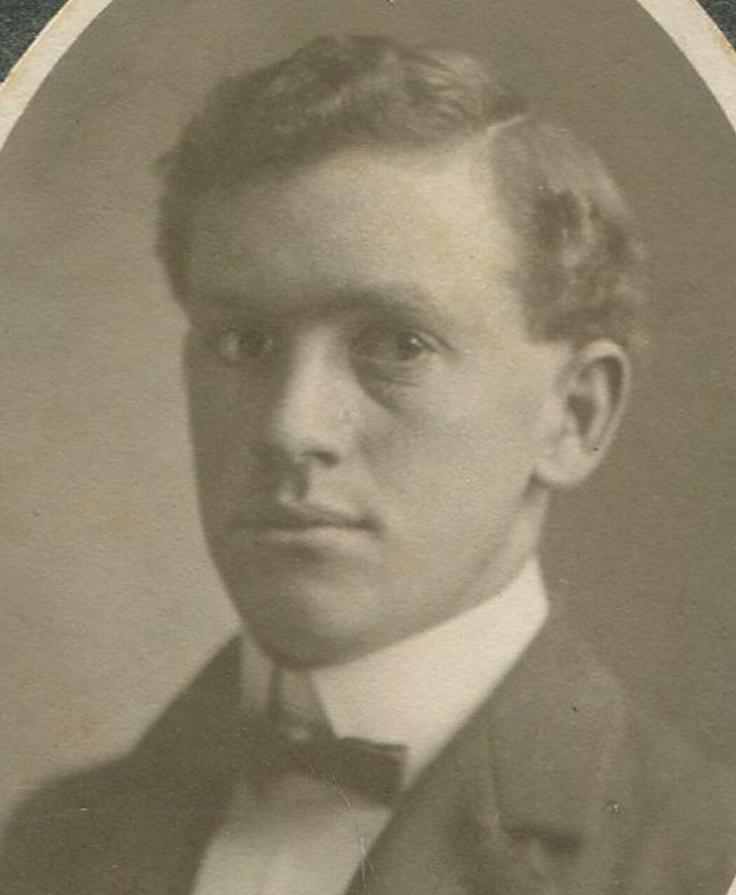 YOUNG MAN WITH EARNEST EXPRESSION, WAVY HAIR. CIRCA 1900.