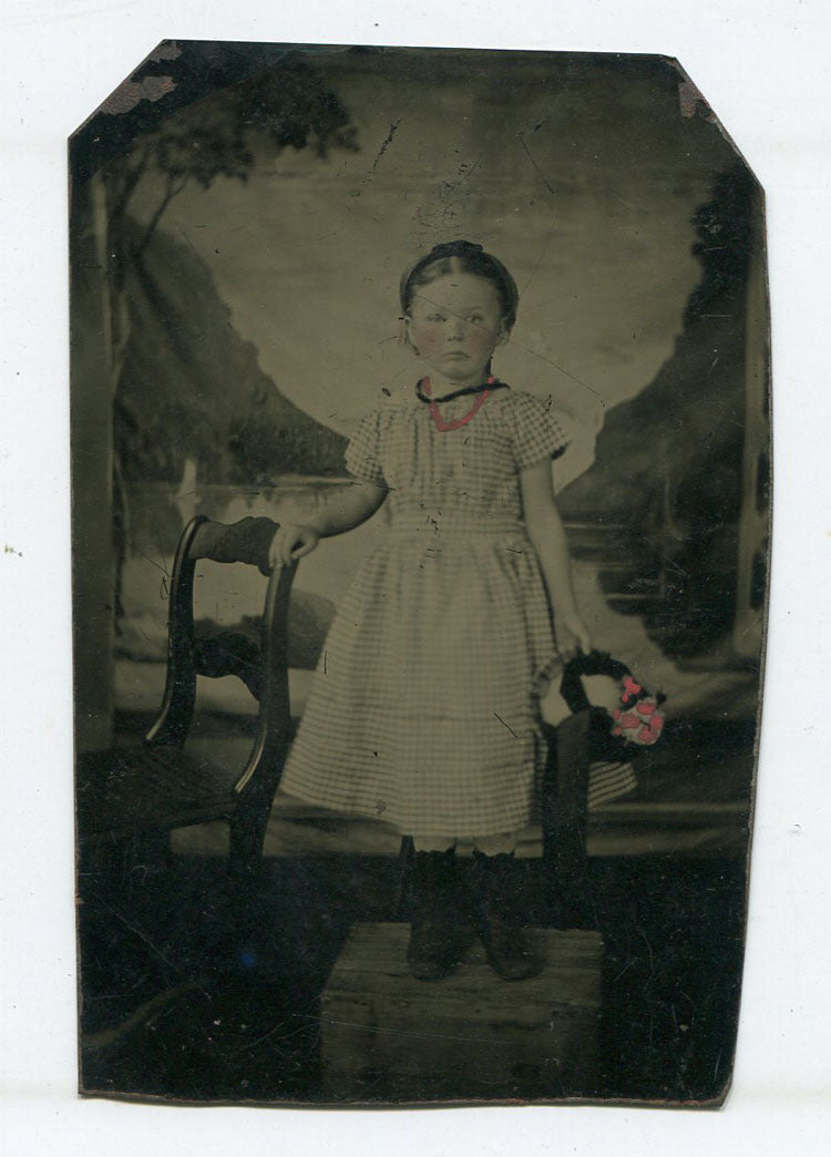 YOUNG GIRL CHECKER DRESS, TINTED FLOWERS, NECKLACE. PAINTED BACKGROUND. TINTYPE.