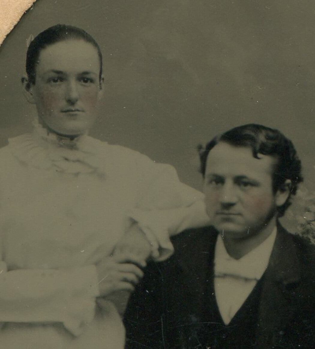 WOMAN LEANING ON MAN SEATED AT TABLE. TINTYPE IN PERIOD PAPER MAT.