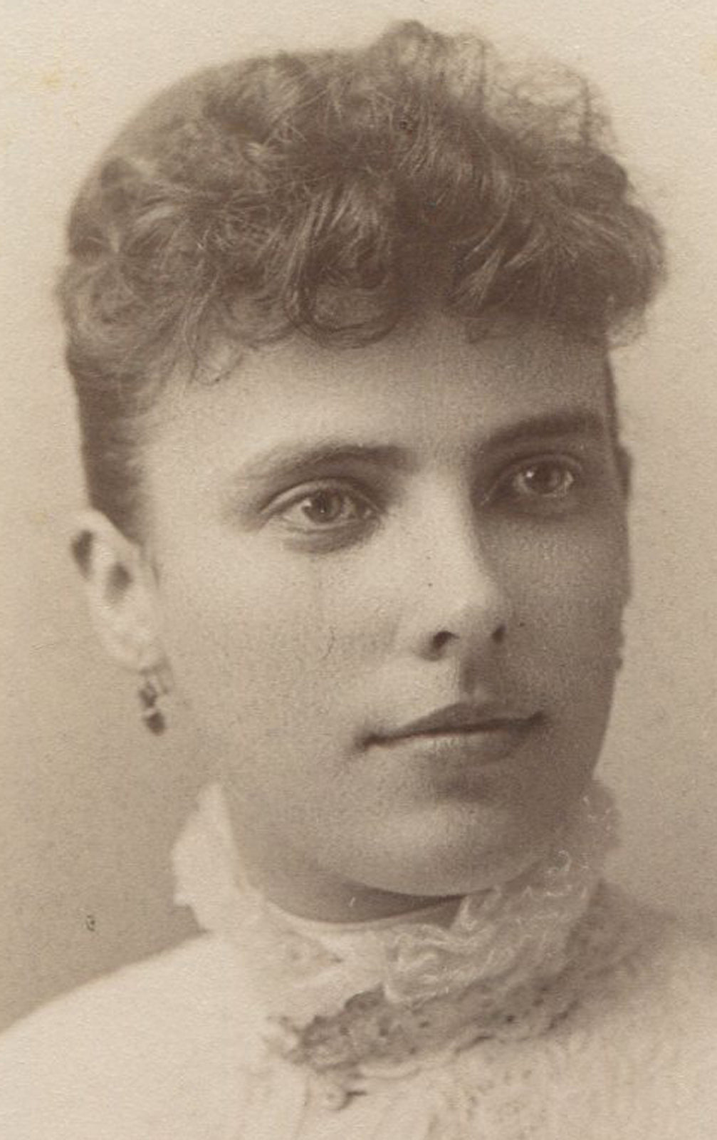 WOMAN W FUZZY BANGS, HIGH LACE COLLAR, EARRINGS. CABINET CARD.SAGINAW, MICHIGAN.