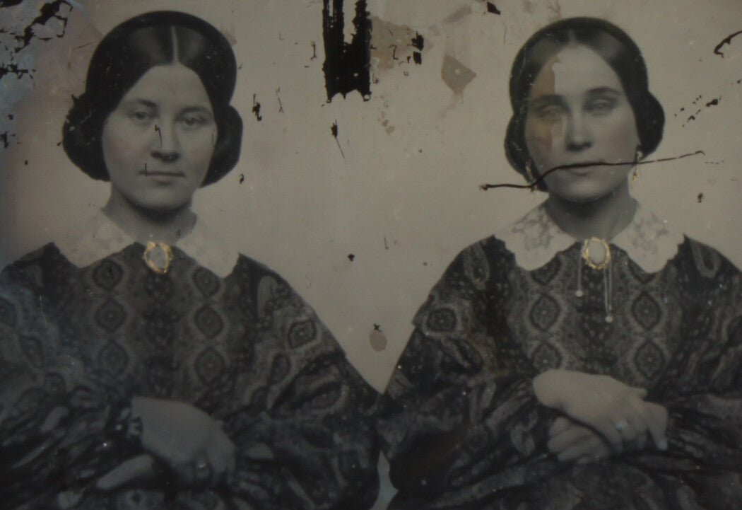 SISTERS IN MATCHING DRESSES. TINTED AMBROTYPE, RUBY GLASS, 6TH PLATE, NO CASE.