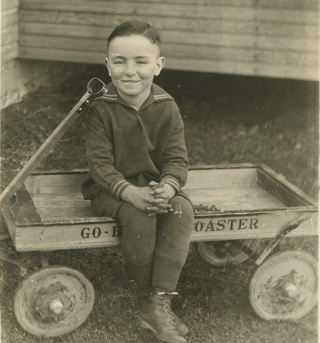 BOY IN SAILOR TOP SITTING ON TOY WAGON. PHOTO POSTCARD.