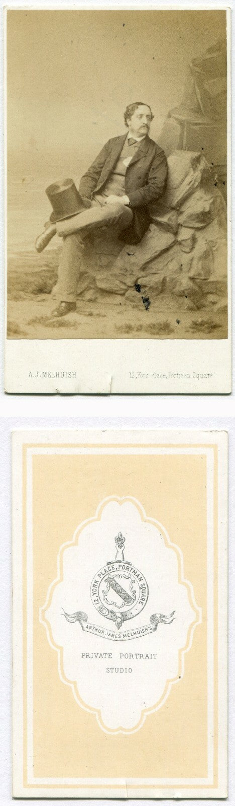 MAN IN RELAXED SEATED POSE ON ROCKS, HOLDING TOPHAT. STUDIO SETTING. CDV. LONDON