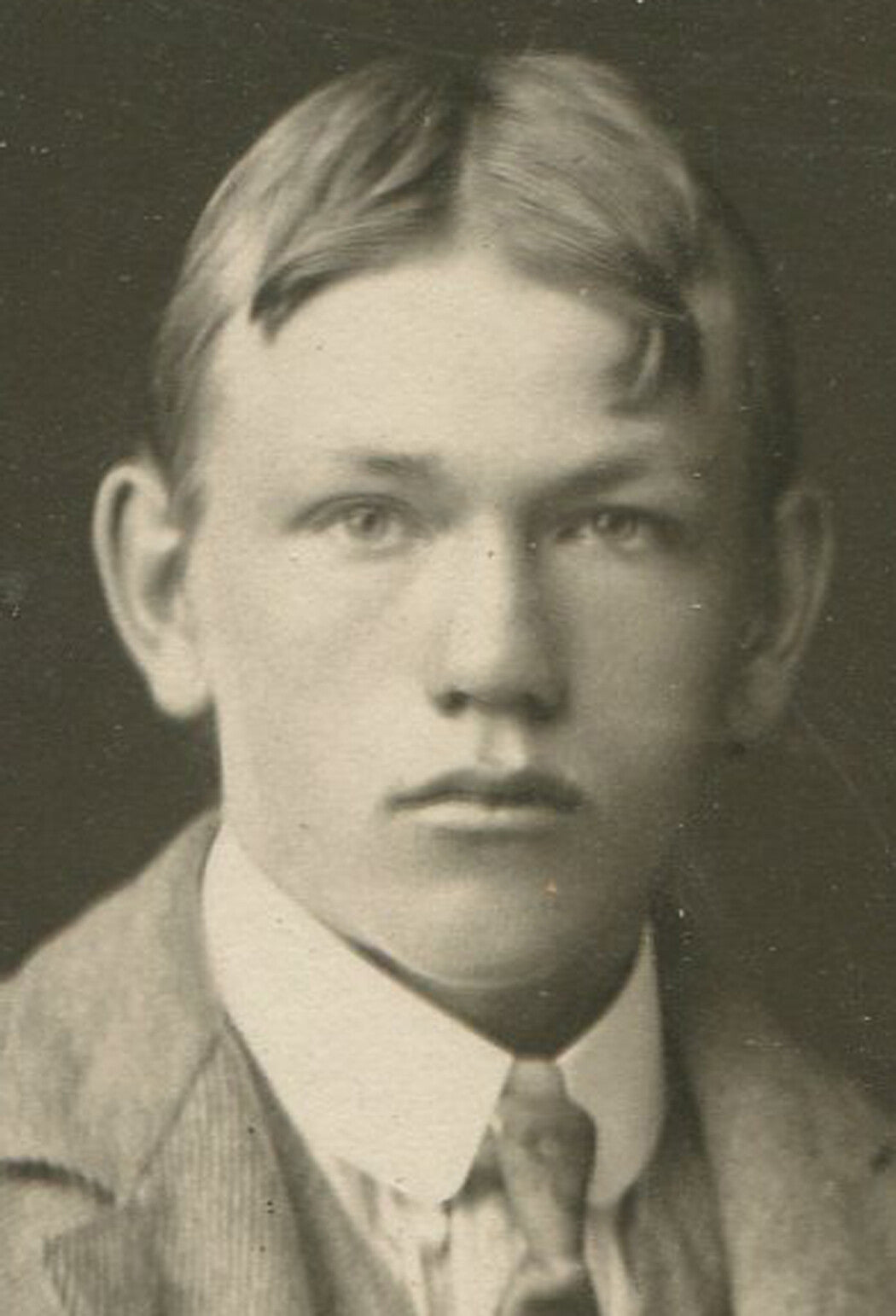 STURDY, BRAWNY YOUNG MAN WITH CENTER PARTED HAIR AND WOOL SUIT. CIRCA 1900.