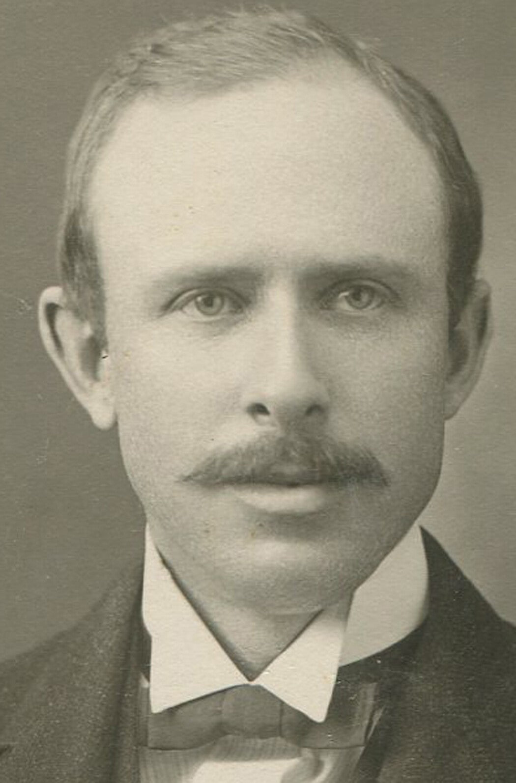 Vintage silver print portrait of mustached man with receding hairline, circa