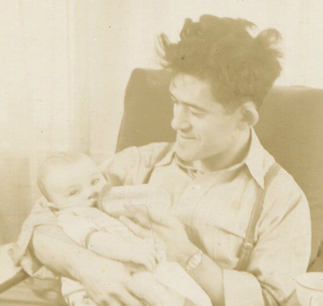 SLEEPLESS DISHEVELED FATHER FEEDING BABY. SILVER PRINT. 1940s.