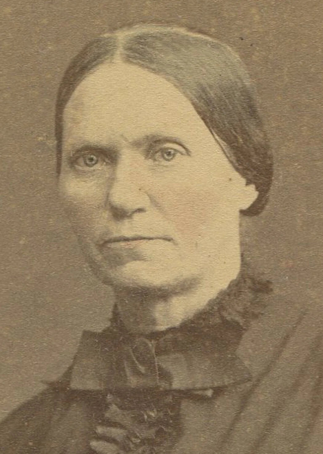WOMAN POSED AT TABLE WITH BOOK. TINTED OVAL ALBUMEN. 7.5 X 5.25 INCHES.