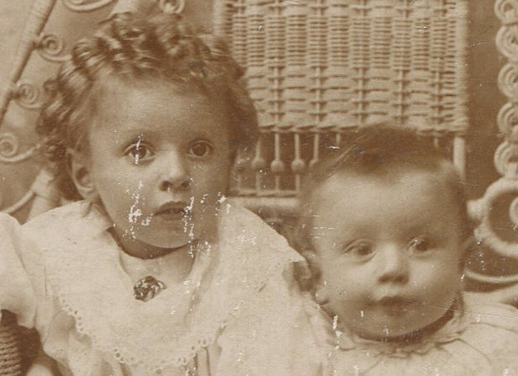 Vintage cabinet card photo: two very young siblings squeezed on wicker chair,