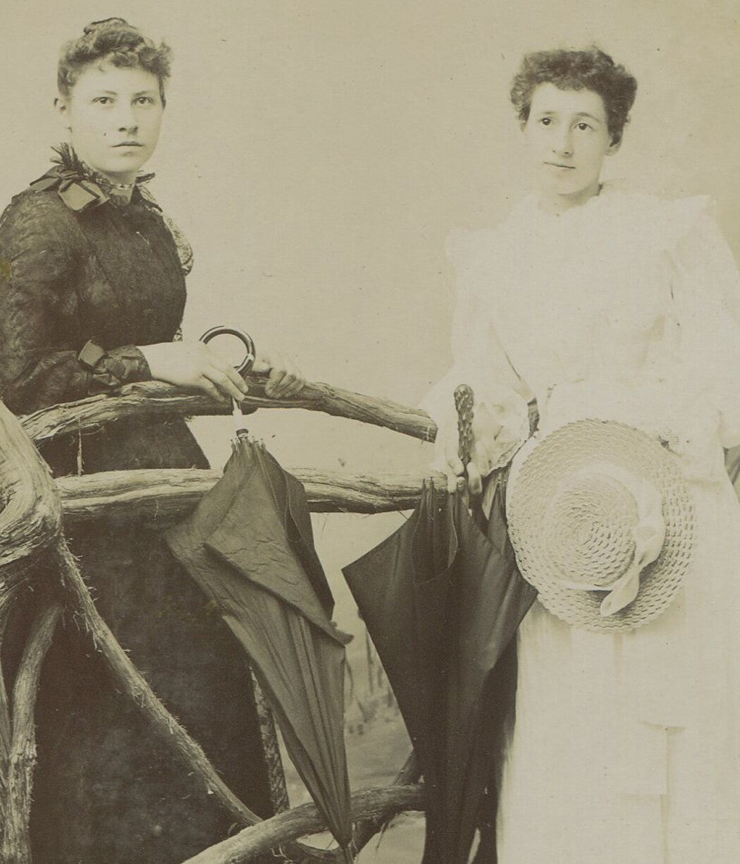 Vintage cabinet card photo: two women with umbrellas and hats on rainy day,