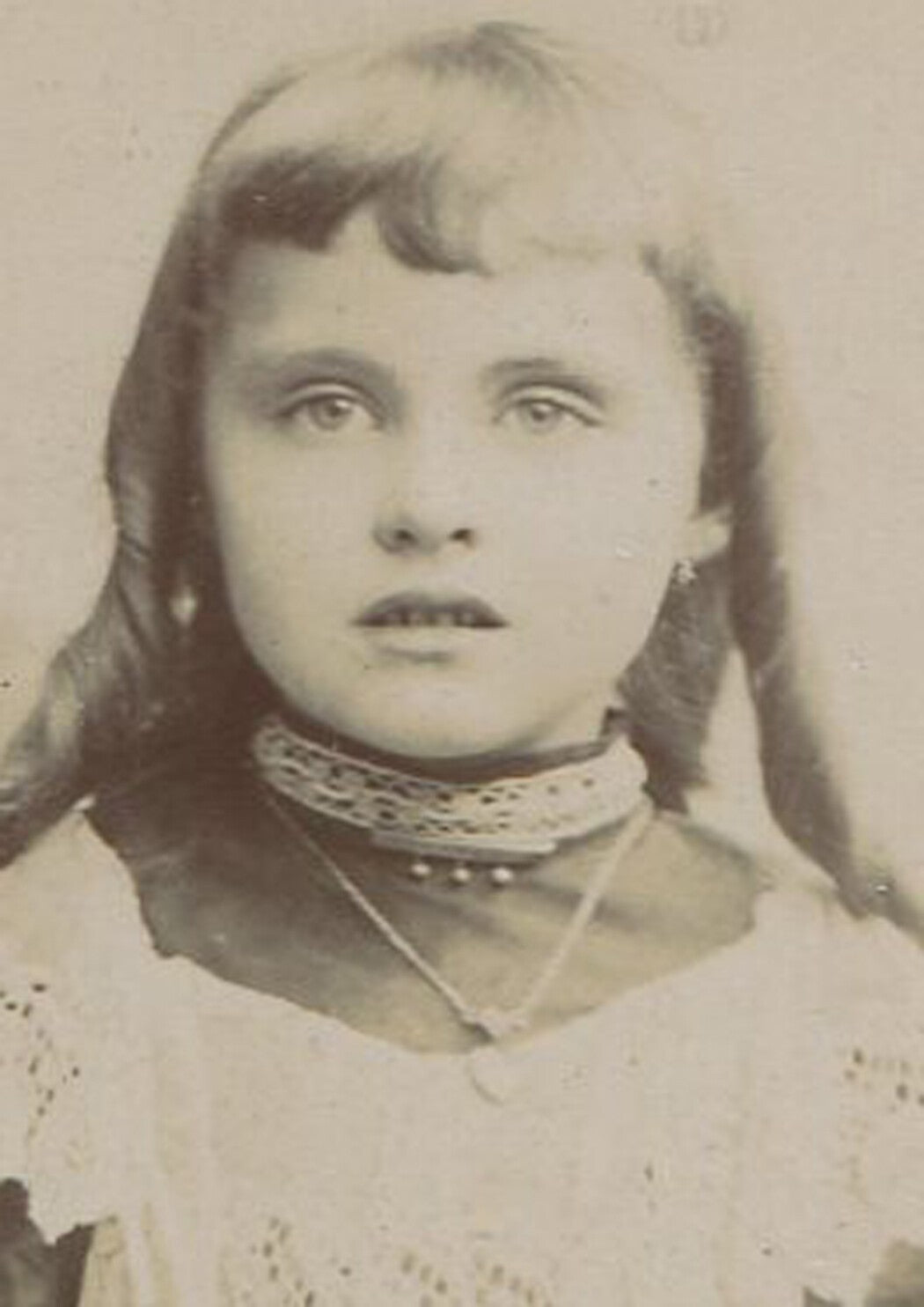 Vintage cabinet card portrait: Young girl with long ringlet curls at a gate -