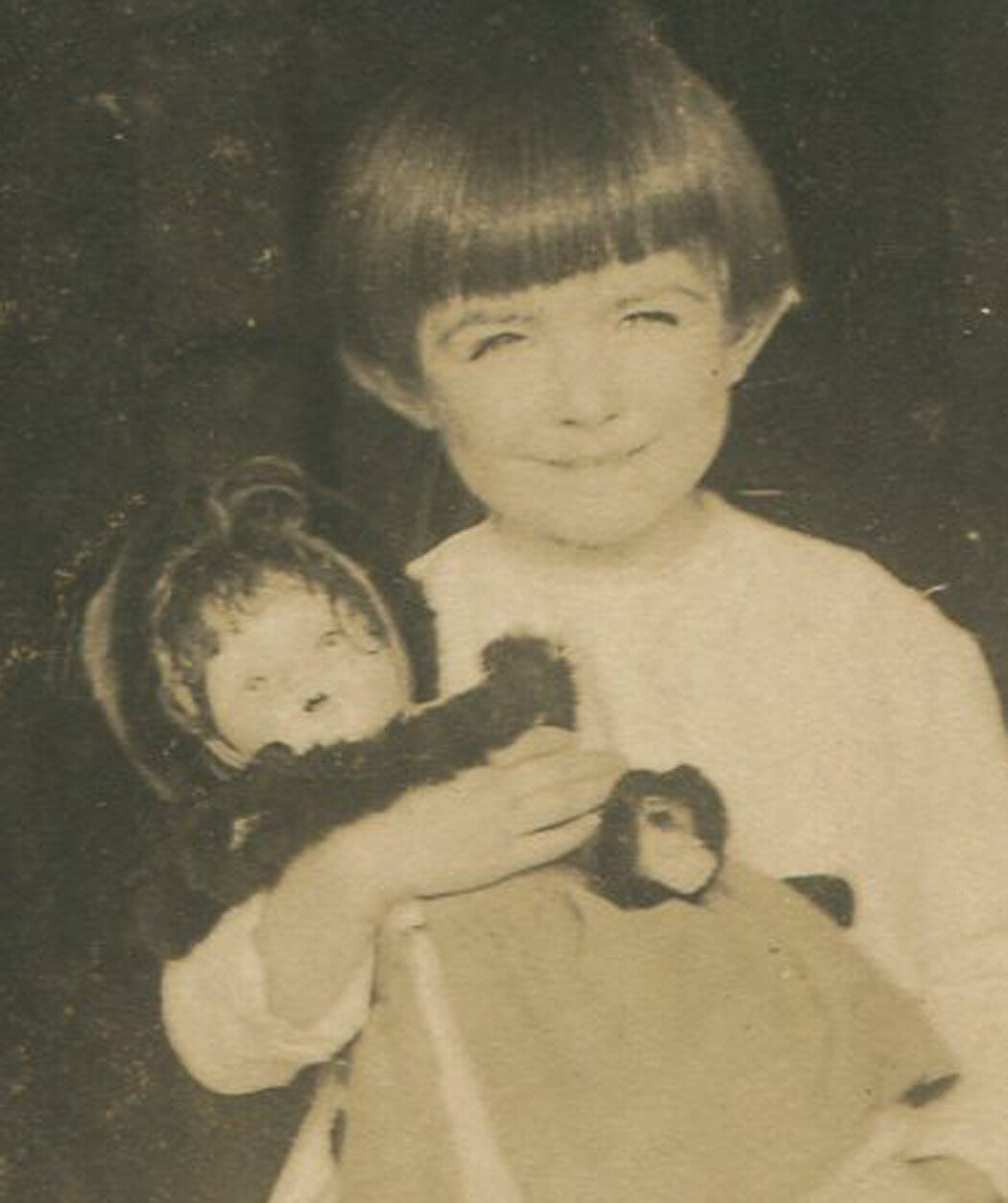 GIRL HOLDING DOLL. PHOTO POSTCARD.