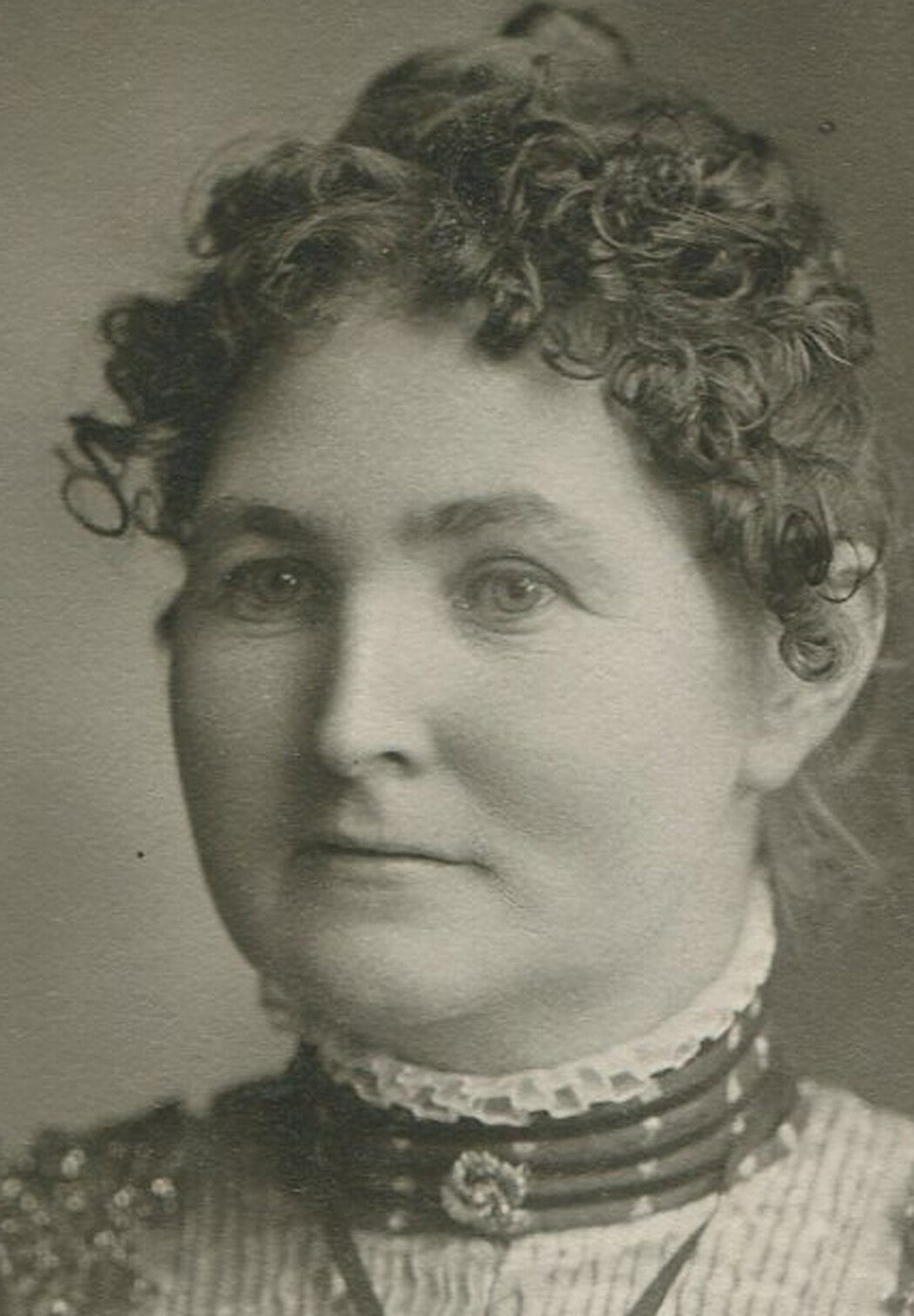 Vintage cabinet card portrait: woman with wavy hair in a busy dress; authentic