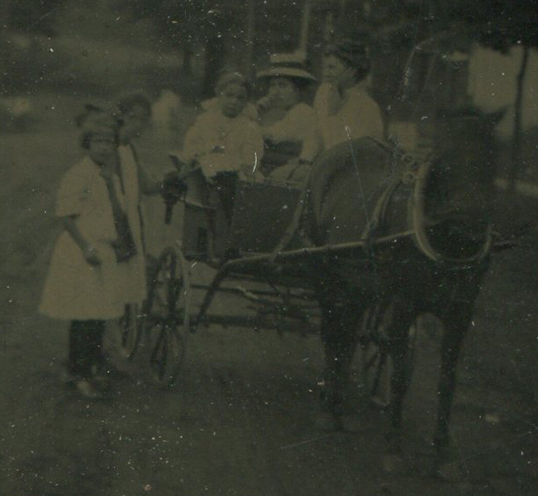 FAMILY W/ HORSE AND WAGON. TINTYPE IN PERIOD PAPER MAT.