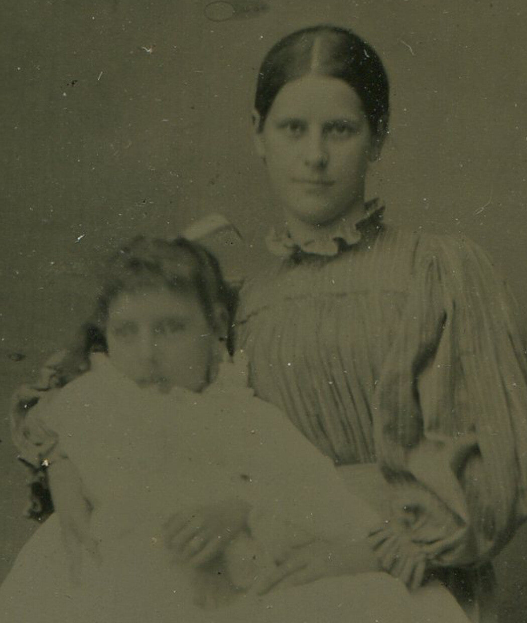 MOTHER HOLDING DAUGHTER ON LAP. TINTYPE IN PERIOD PAPER MAT.