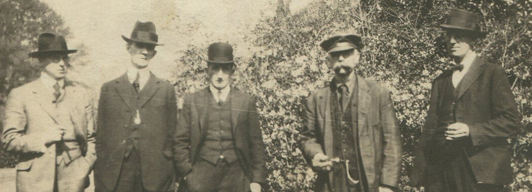 MEN IN HATS, SQUINTING IN THE SUN. 1920 TONED SILVER PRINT, 2.5 X 4 INCHES.