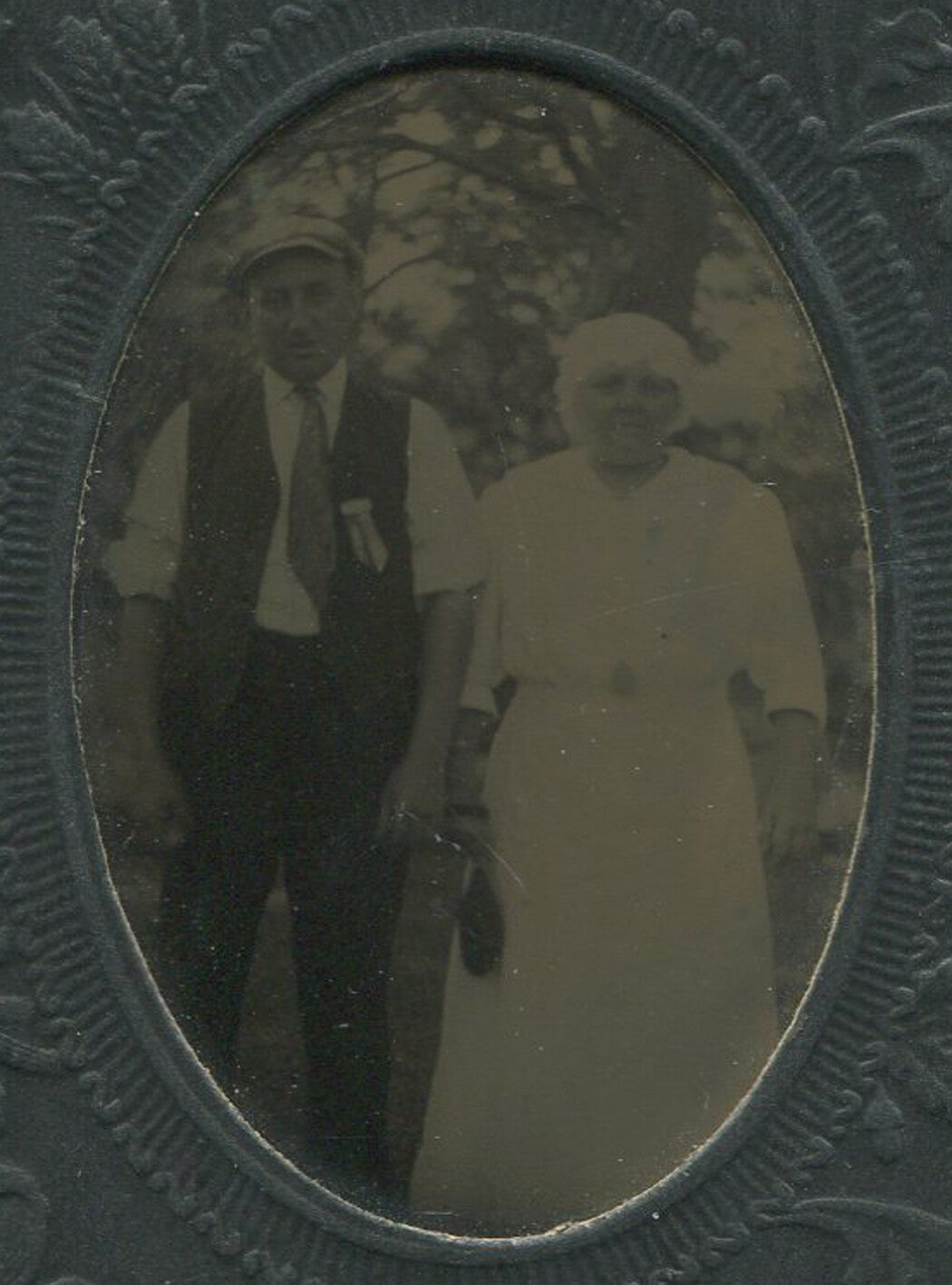 OLD COUPLE POSED IN OUTDOORS.TINTYPE IN PERIOD EMBOSSED MAT.