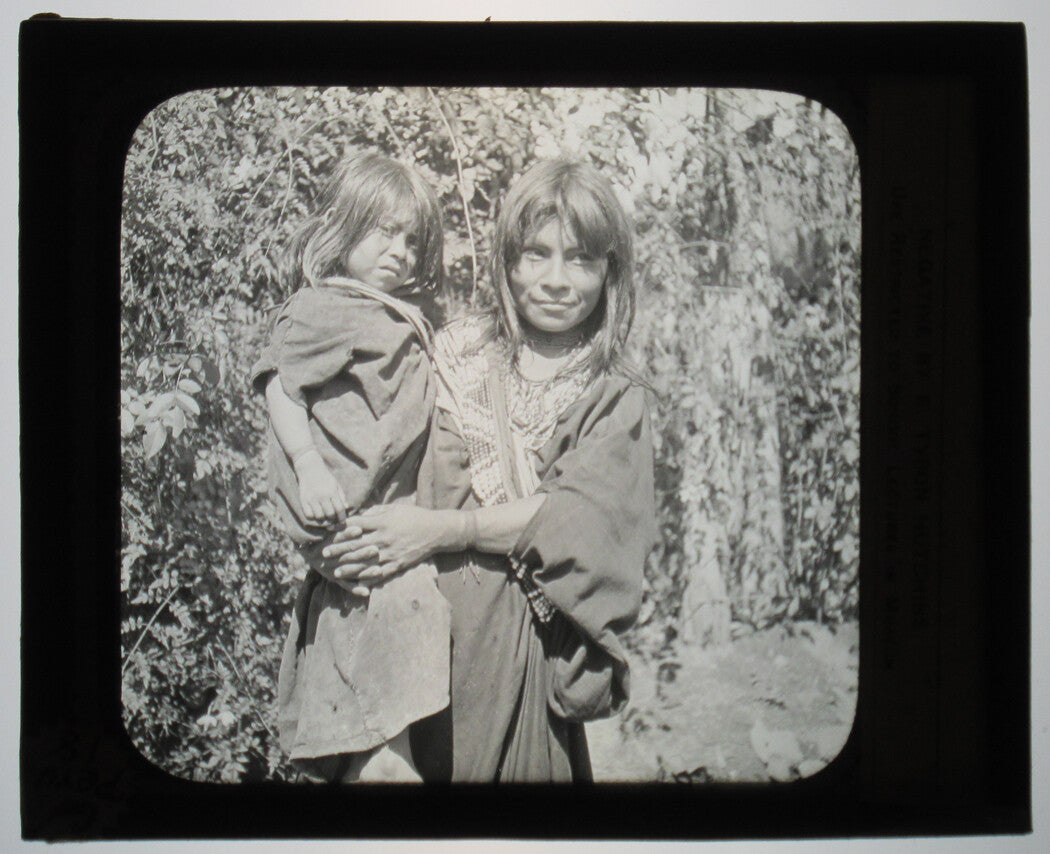 INDIGENOUS WOMAN HOLDING YOUNG CHILD. PERENE, PERU. PHOTO ON GLASS.