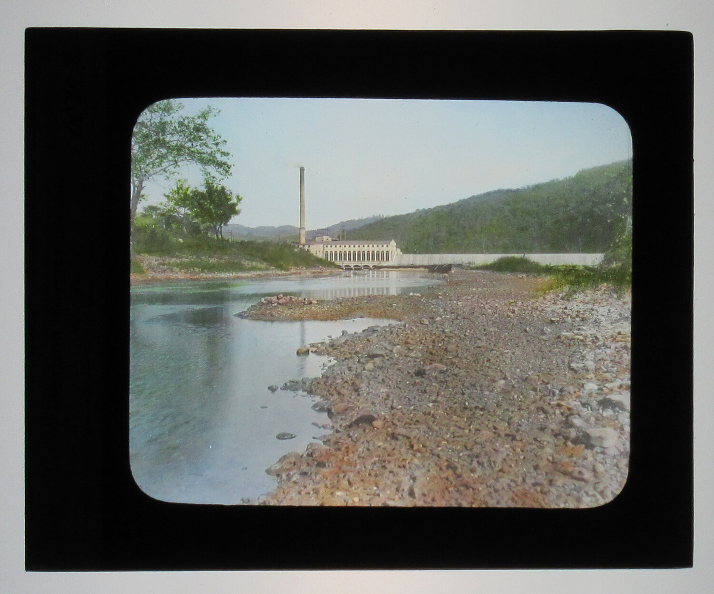 LOW DAM W/POWER PLANT. TINTED PHOTO ON GLASS. HAND COLORED PHOTO ON GLASS.