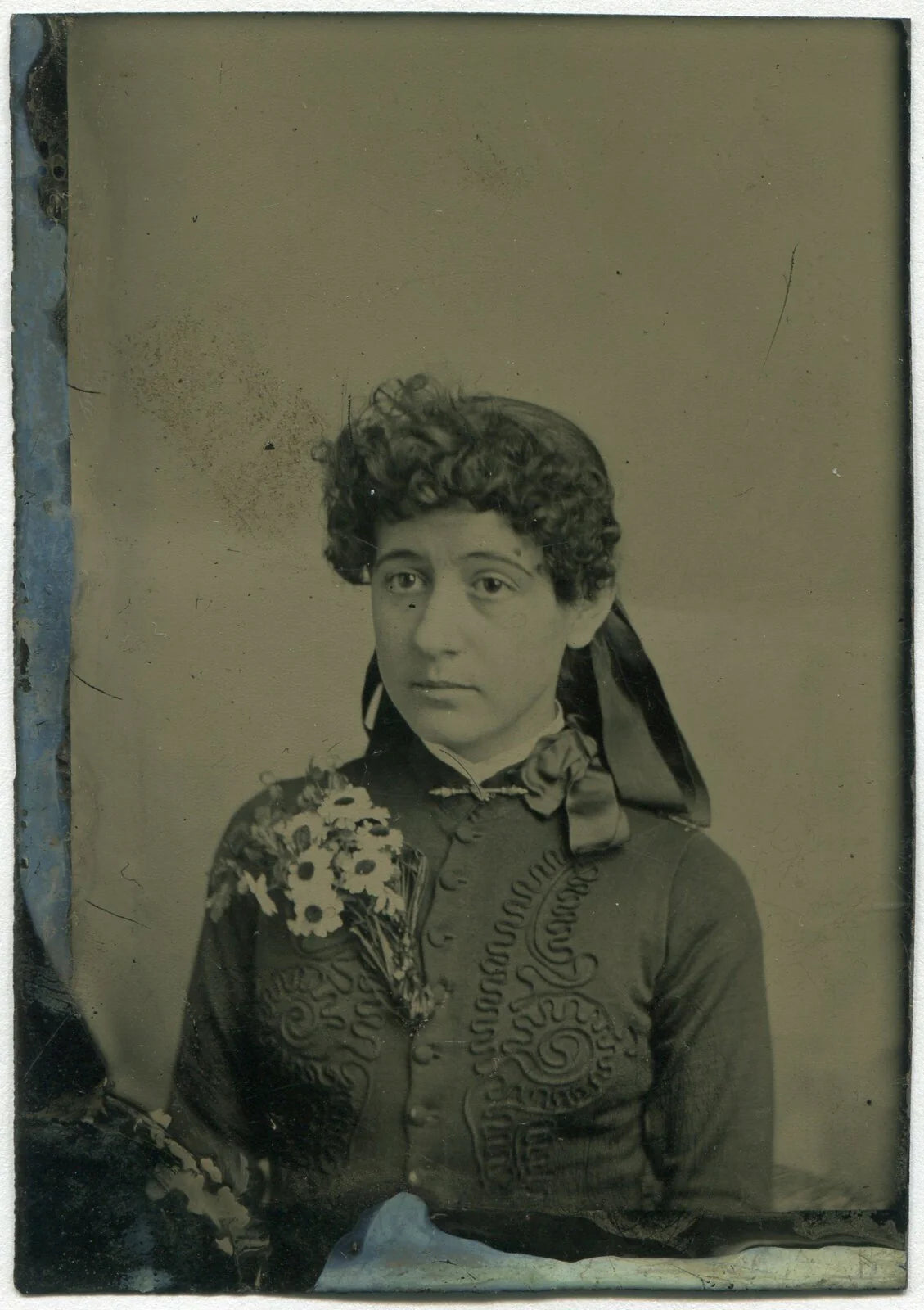 YOUNG WOMAN WITH CURLY BANGS, BIG FLOWER PIN. TINTED TINTYPE.
