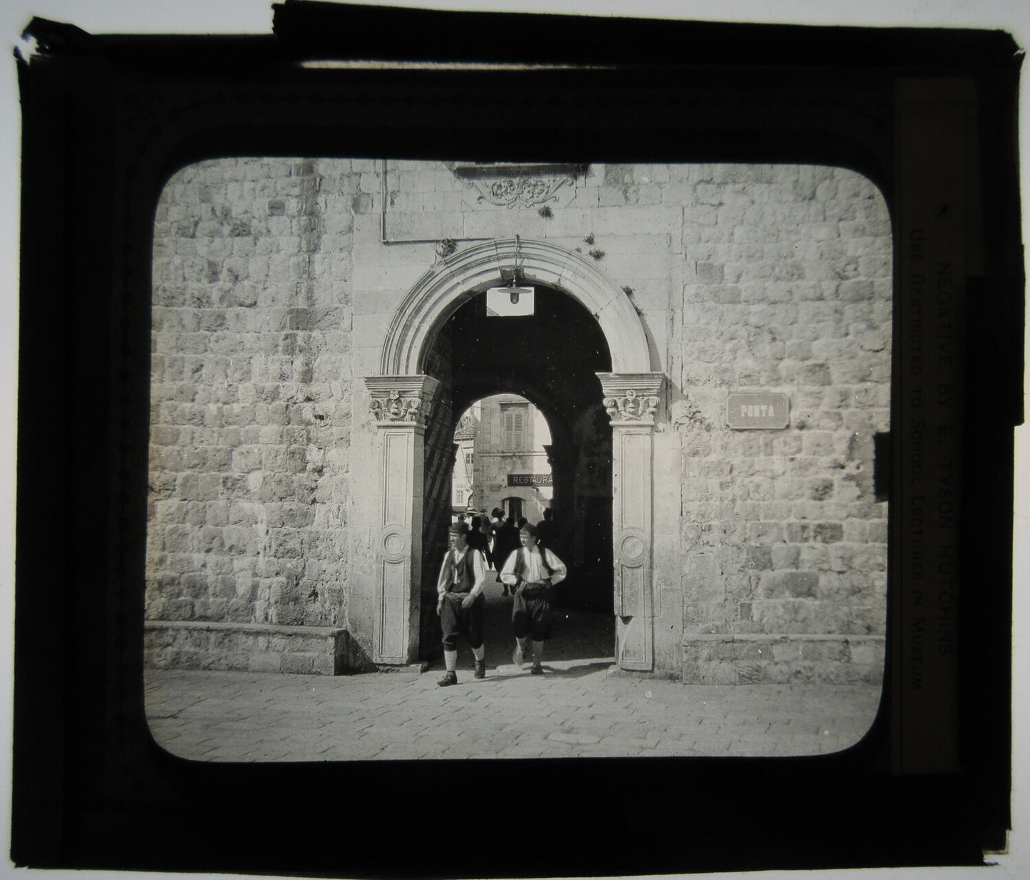 MEN IN STONE DOORWAY, TRADITIONAL DRESS. BALKANS. PHOTO ON GLASS.
