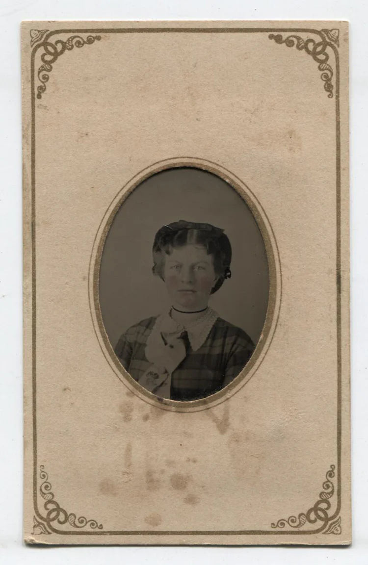 TINTYPE WOMAN WITH HAIR BOW, PLAID DRESS AND TINTED CHEEKS. PERIOD PAPER MAT.