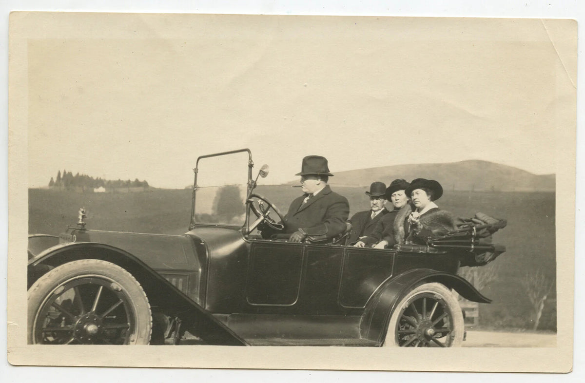 1915 MAN SMOKING CIGAR DRIVING AUTOMOBILE, WIFE/FRIENDS IN BACK SEAT, PHOTO