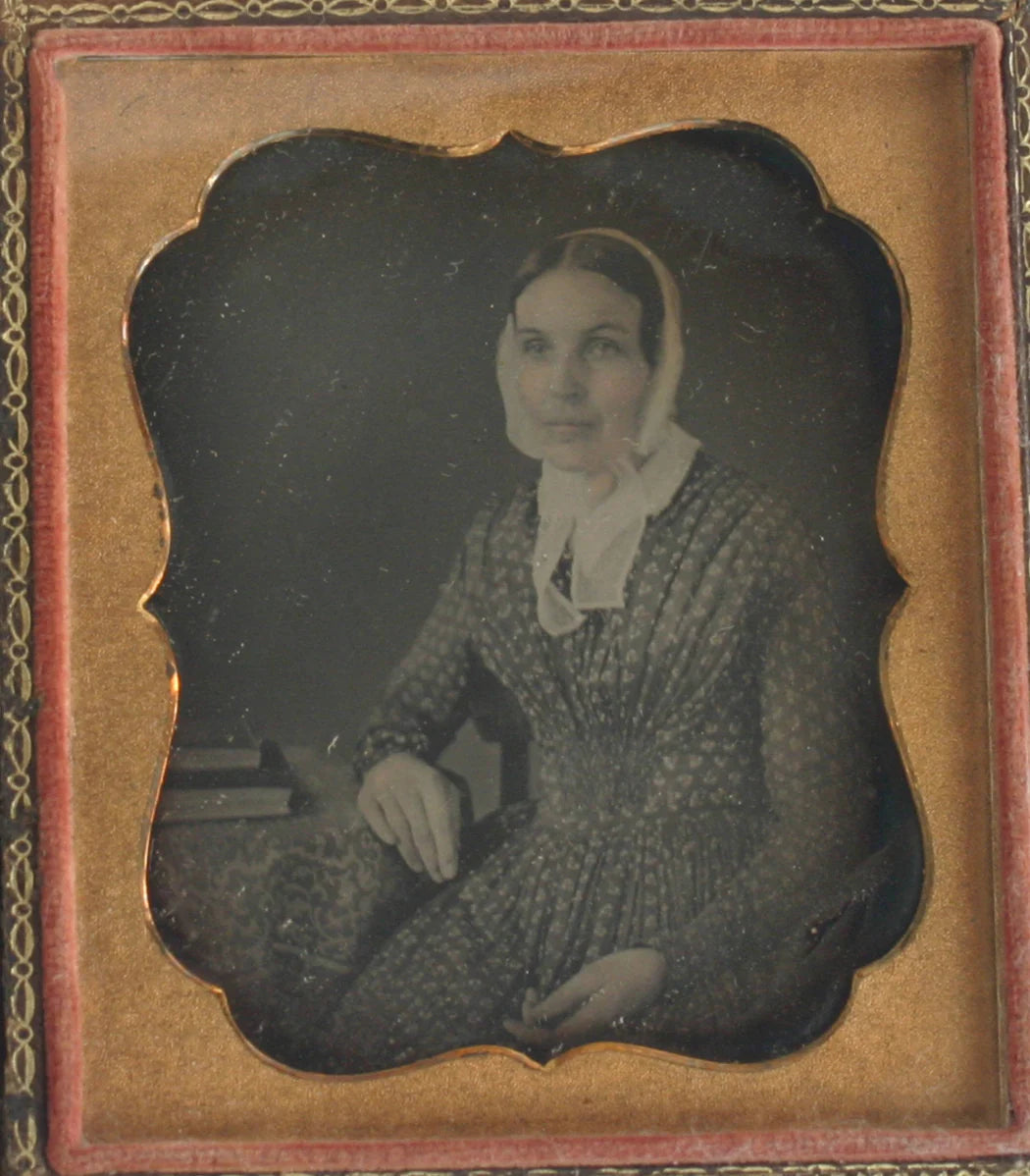 WOMAN IN BONNET, PRINT DRESS. TINTED DAGUERREOTYPE 6TH PLATE, FULL CASE.