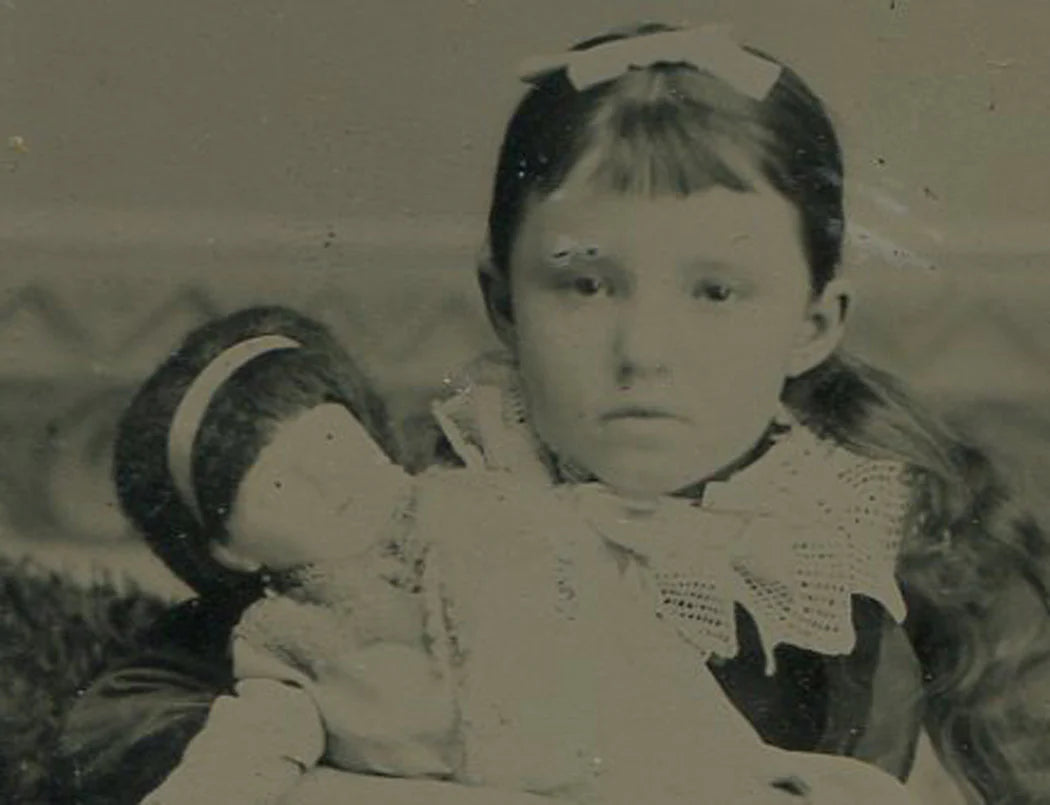 LITTLE GIRL POSED HOLDING BABY DOLL. TINTYPE.