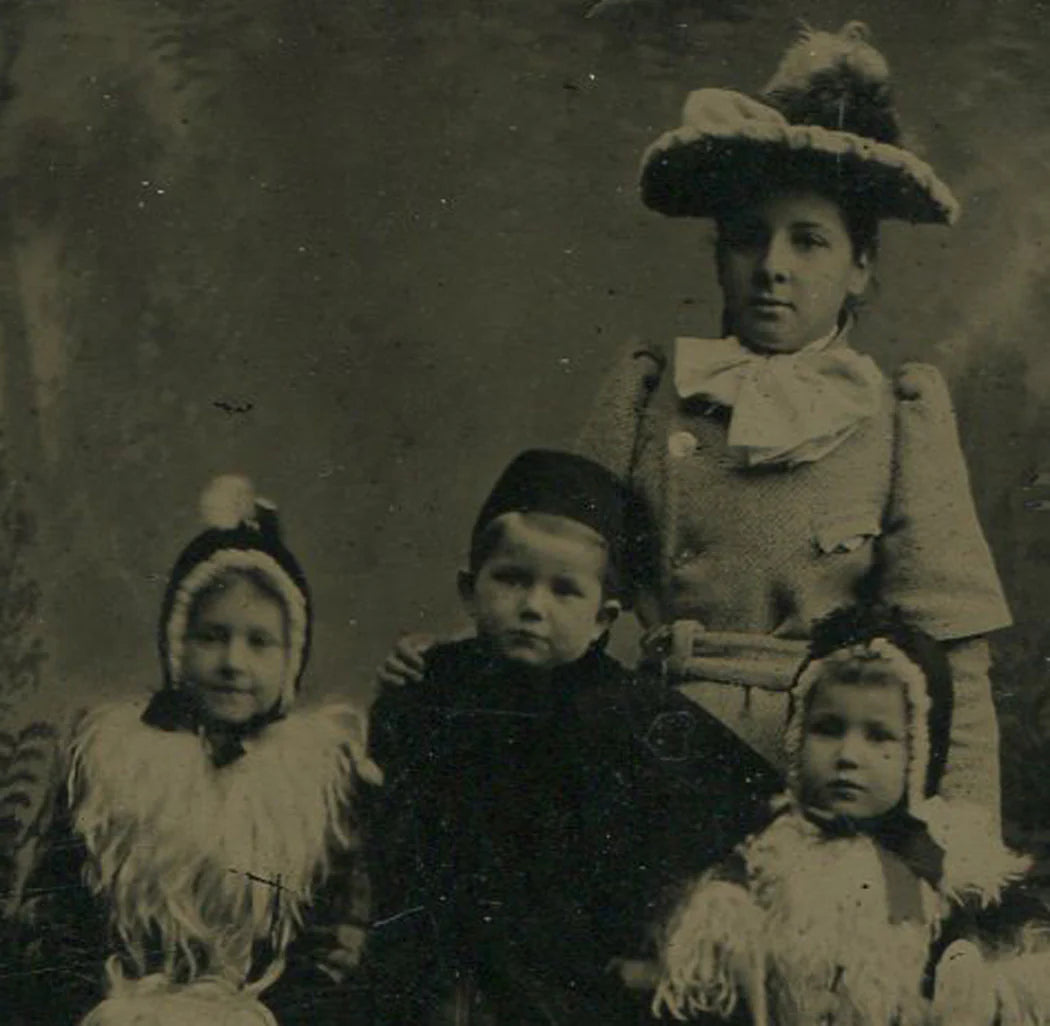 FOUR CHILDREN IN FANCY WINTER CLOTHES. TINTYPE.