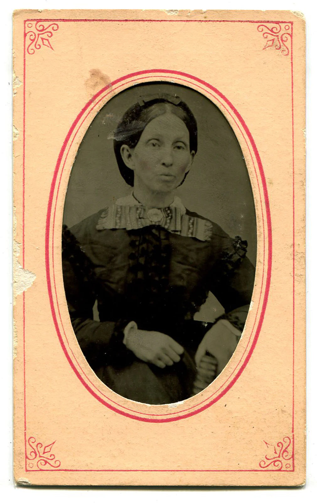 WOMAN WITH PURSED LIPS, LARGE BOW TIE. TINTYPE IN PERIOD PAPER MAT.
