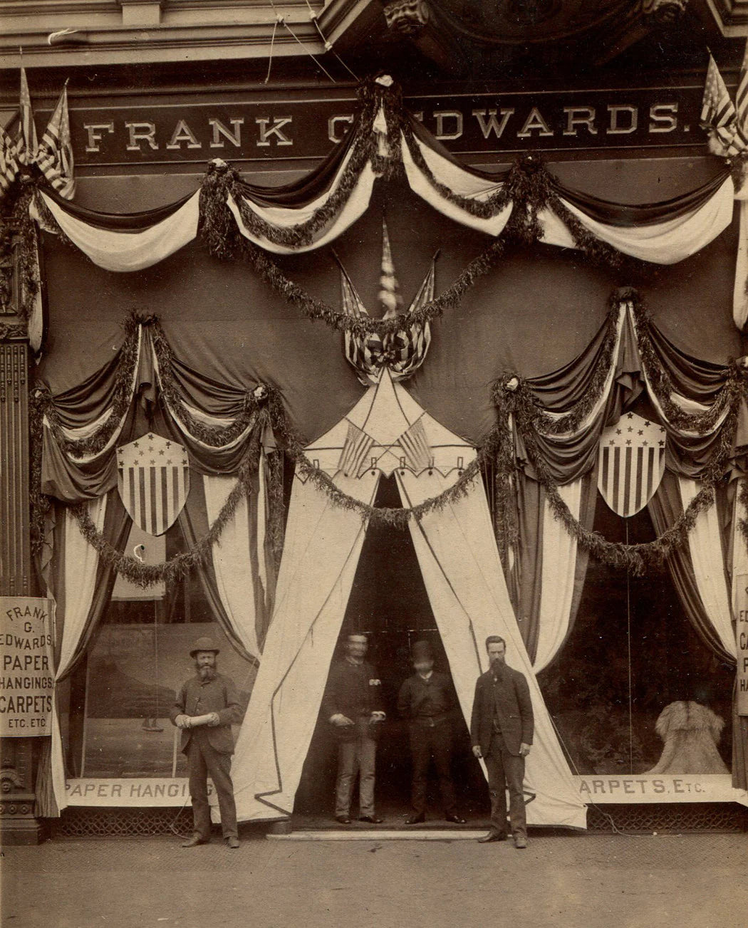 STORE FRONT WITH CELEBRATORY BUNTING. PAPER HANGING AND CARPET STORE.