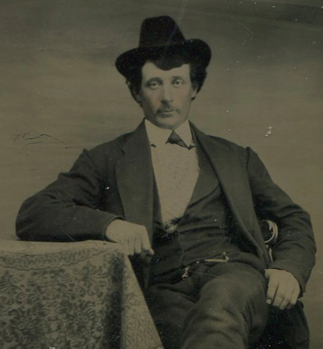 MAN WITH BUSHY HAIR AND SMALL COWBOY HAT. TINTED TINTYPE.