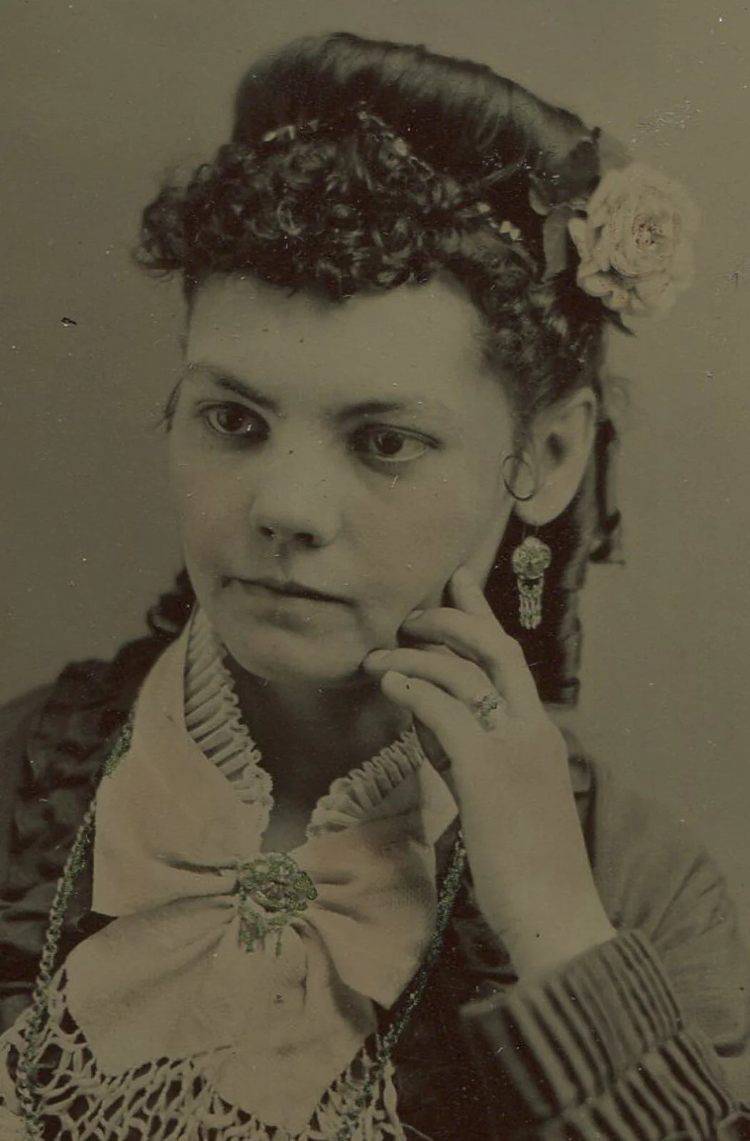 BEAUTIFUL WOMAN IN PENSIVE POSE. TINTED TINTYPE, 6.5 X 5 INCHES.