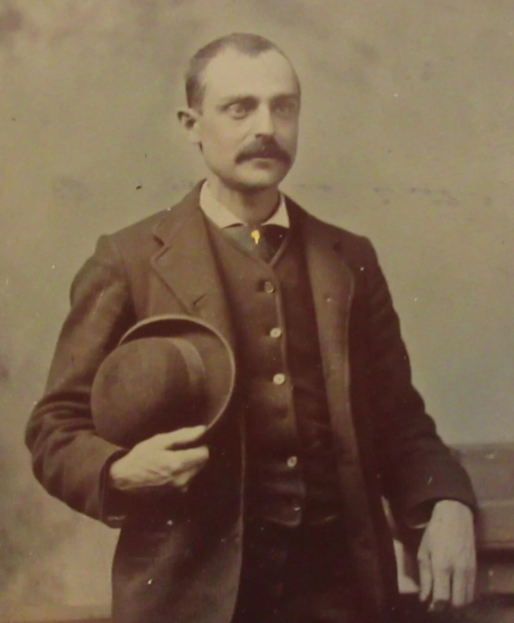 MAN POSED HOLDING BOWLER HAT. TINTED TINTYPE, QUARTER PLATE.