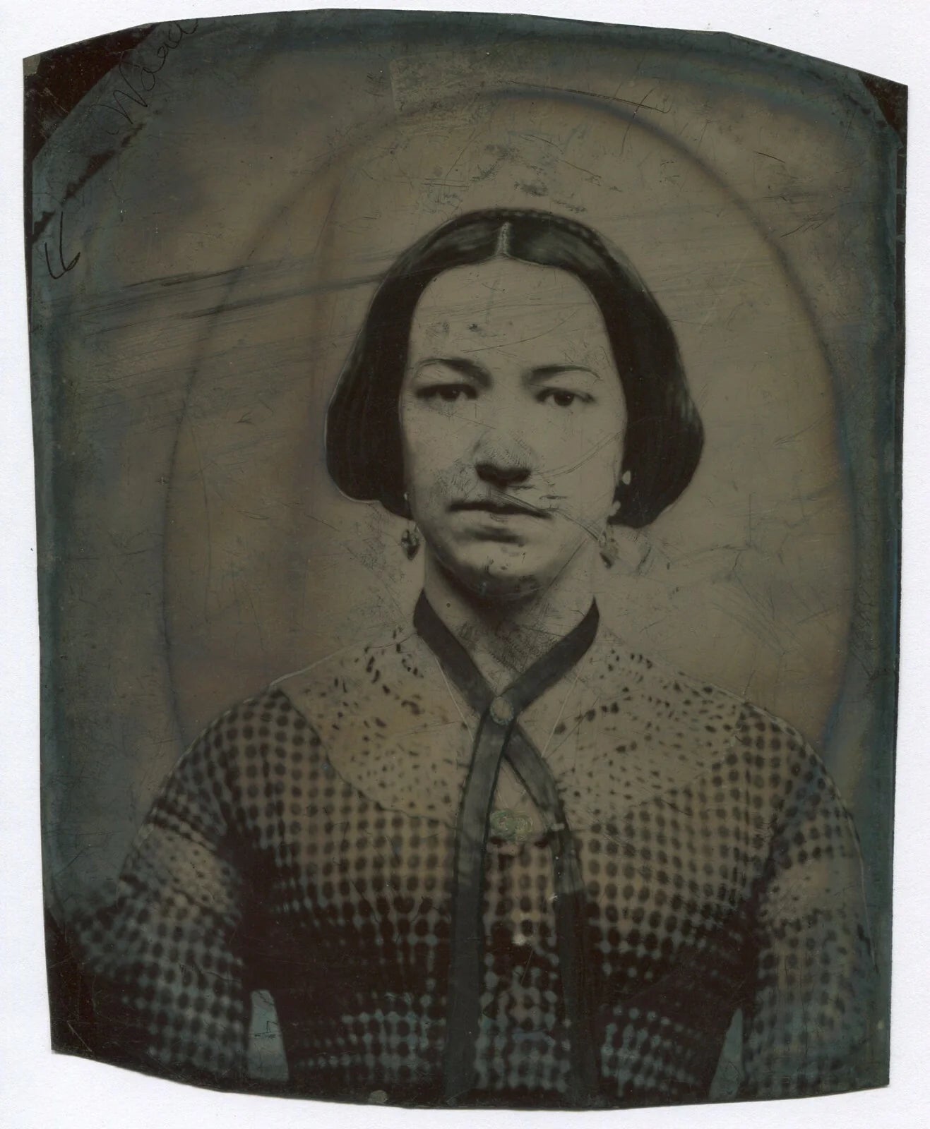 WOMAN IN CHECKERED DRESS, RIBBON NECKLACE, AND EARRINGS. TINTYPE 8.5X7 IN.