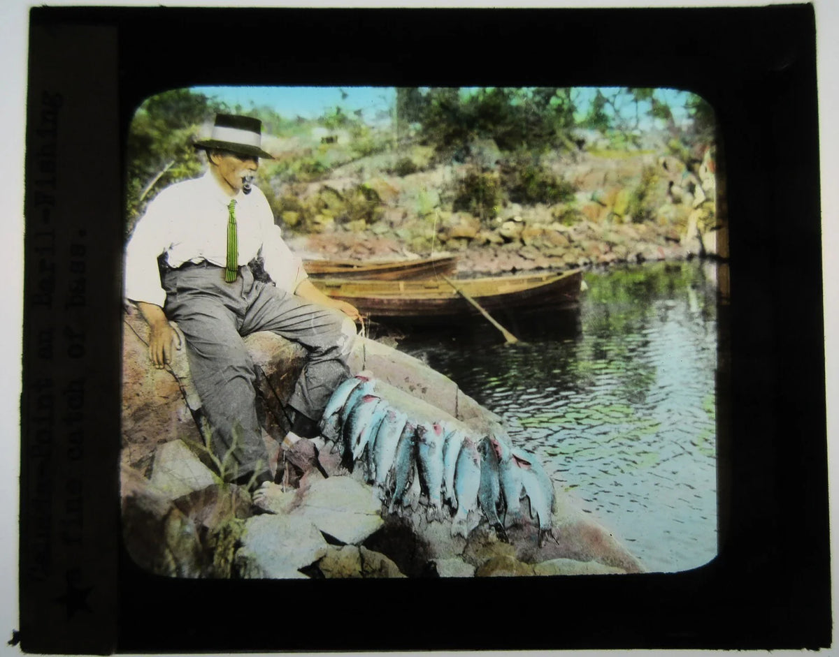 MAN SMOKING PIPE WITH FISH CATCH OF THE DAY. TINTED LANTERN SLIDE.