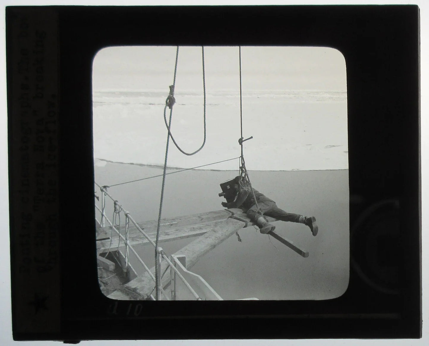 EARLY CINEMATOGRAPHY. MAN SUSPENDED ALOFT W/CAMERA ROLLING. PHOTO ON GLASS.