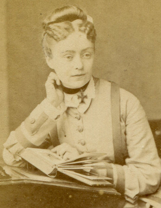 WOMAN WEARING IRON CROSS, POSED READING AT TABLE. CDV. ENGLAND.