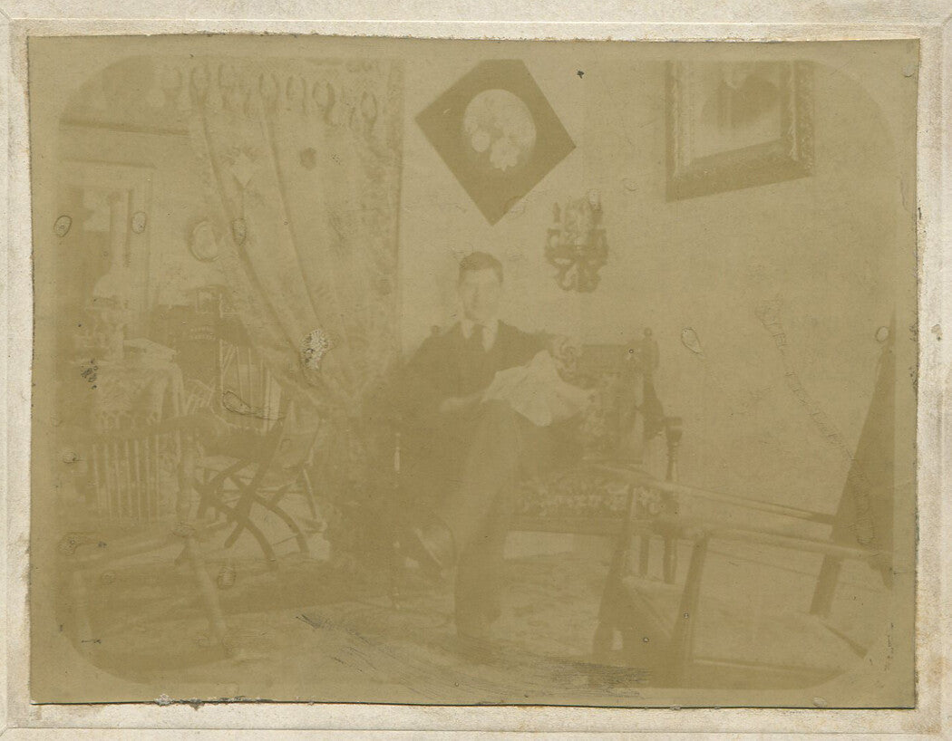 MAN READING NEWSPAPER. CIRCA 1910.