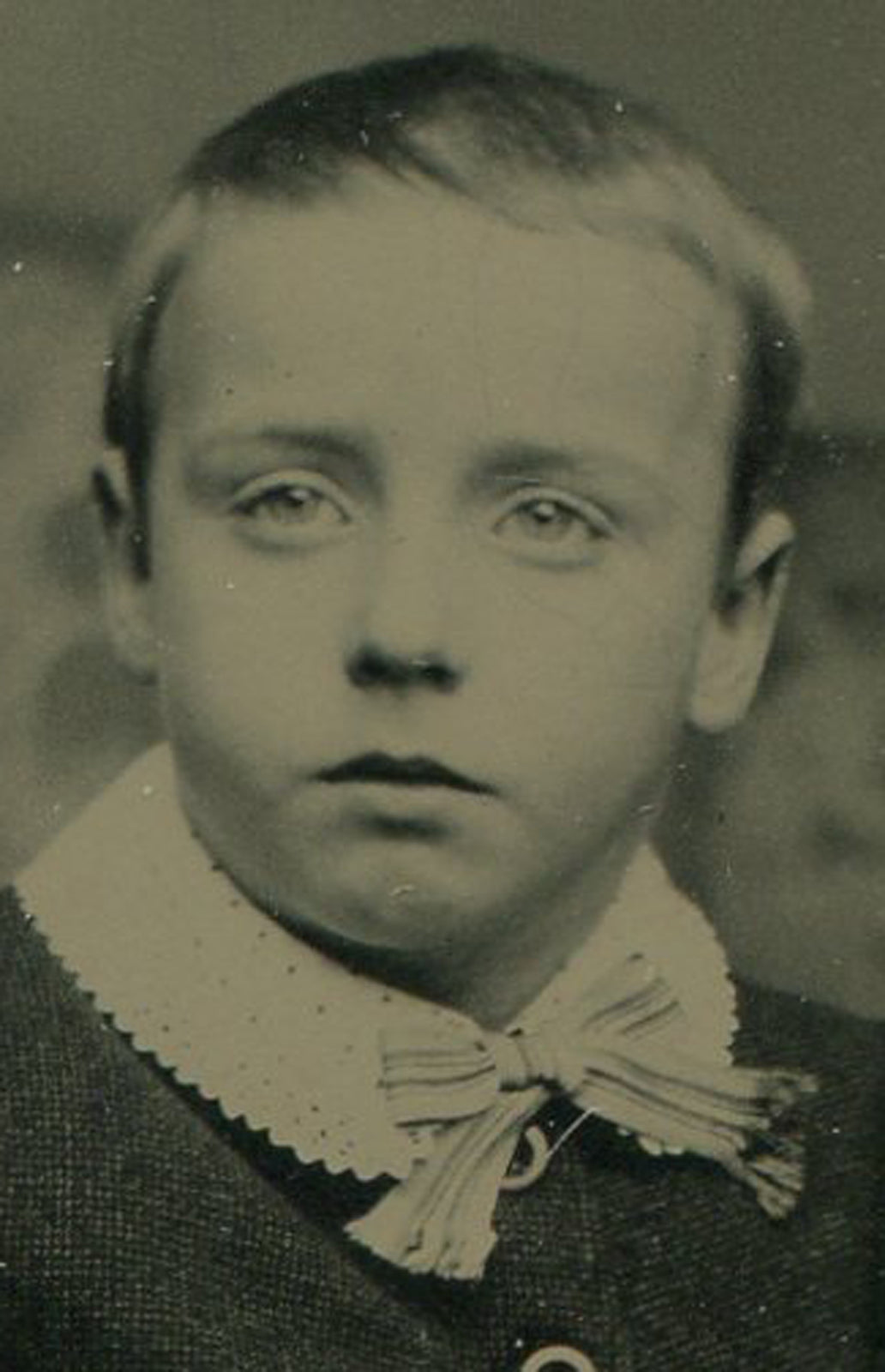YOUNG BOY SEATED POSE, FUTURE EMBEZZLER. TINTYPE IN PERIOD PAPER MAT.
