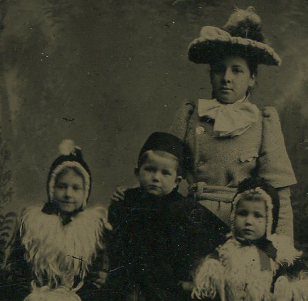 FOUR CHILDREN IN FANCY WINTER CLOTHES. TINTYPE.