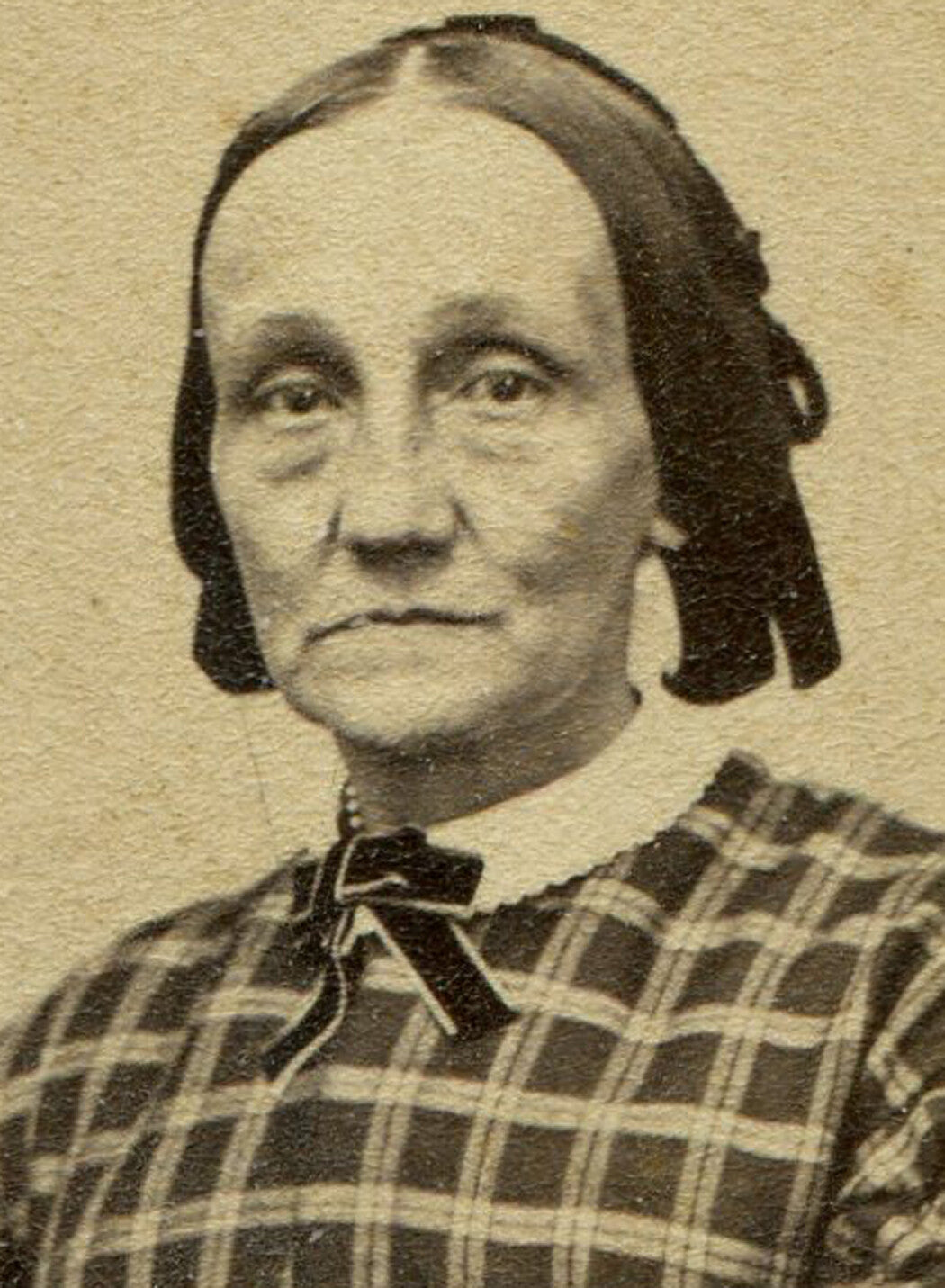 OLDER WOMAN, GAUNT FEATURES, PLAID DRESS. ORNATE PRINTED OVAL FRAME ON CDV CARD.
