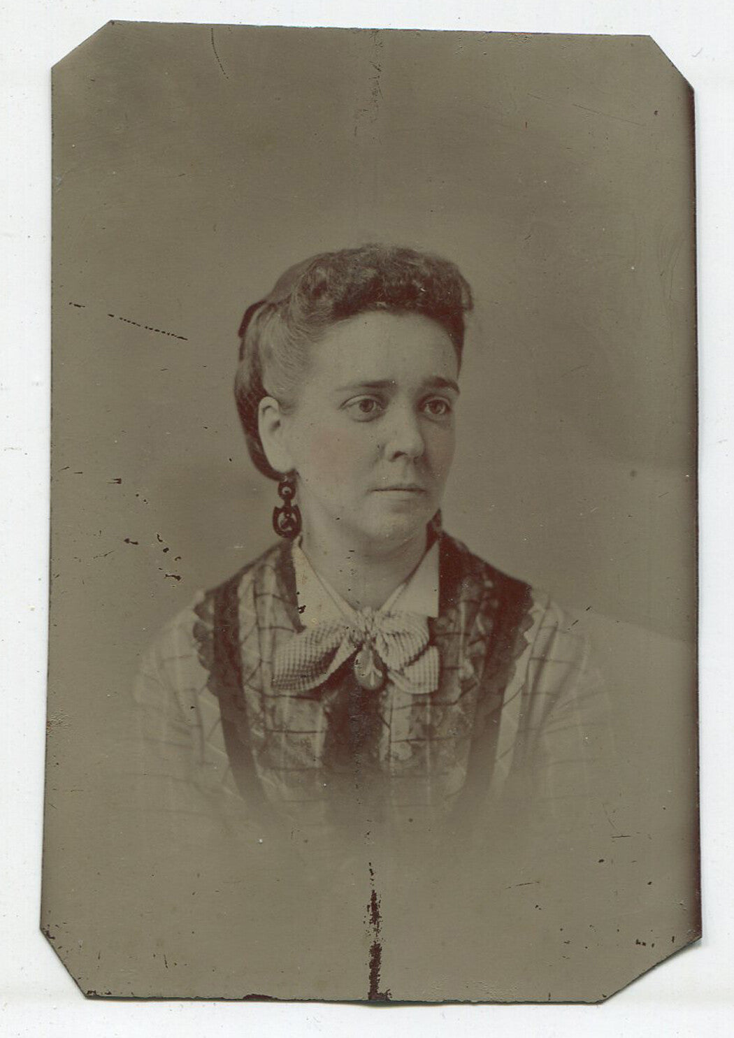 WOMAN WITH EARRINGS AND RICHLY TEXTURED TOP. TINTED TINTYPE.