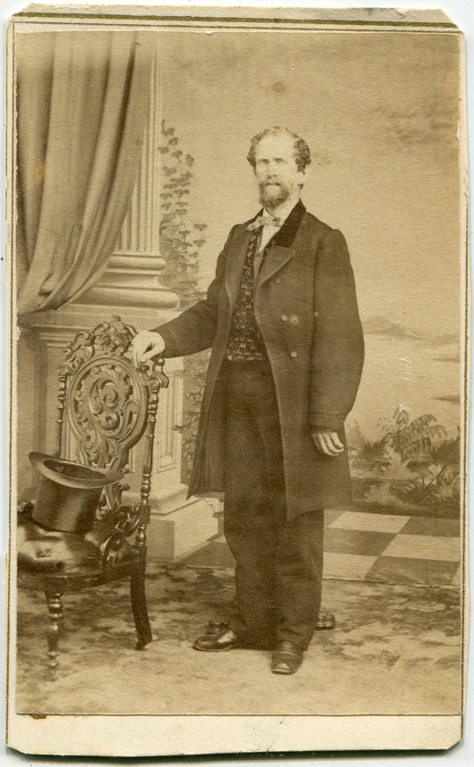 MAN STANDING AT CHAIR, HAT ON SEAT. PAINTED BACKGROUND. CDV. SAN FRANCISCO, CA.