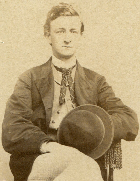 MAN POSED HOLDING HAT, SEATED WITH LEGS CROSSED. CDV.
