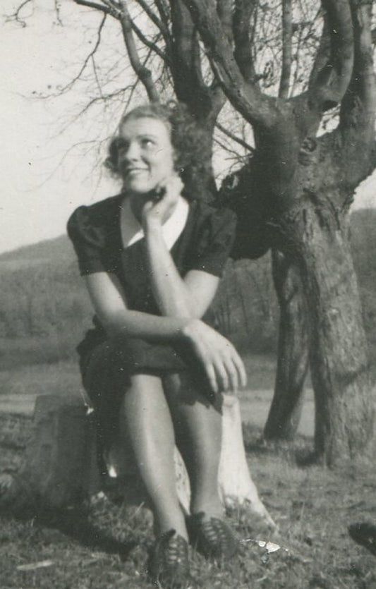 WOMAN SEATED AT FOOT OF BARE TREE. SILVER PRINT 5 X 3.25 INCHES. 1950s.